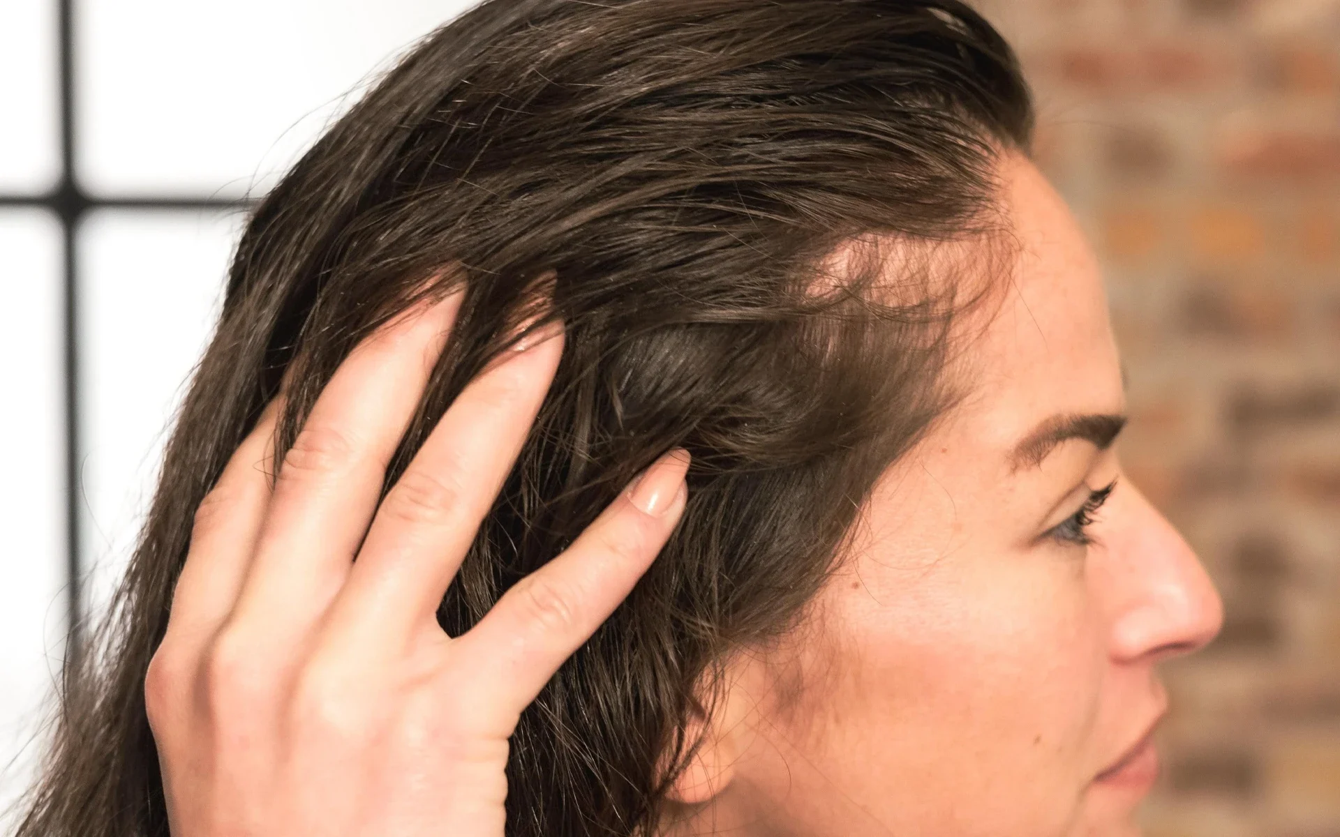 Person touching scalp with fingers